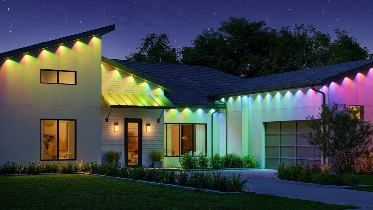 Color-changing permanent lighting along a modern home roofline at night