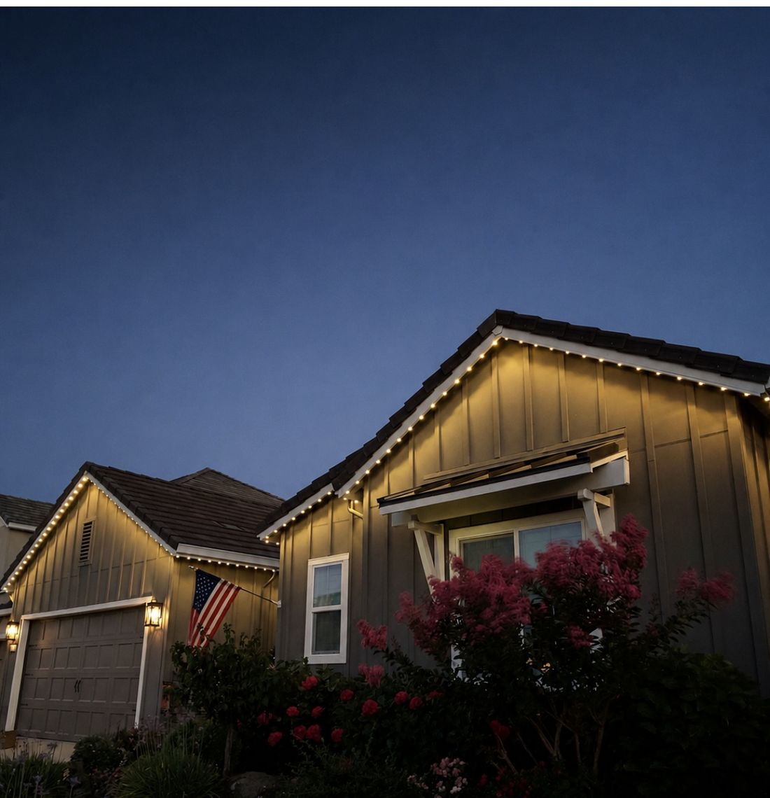 Home exterior with warm permanent lighting installed along the roofline at dusk