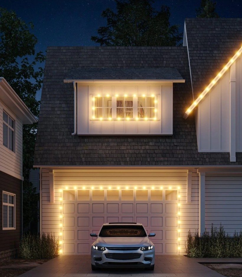 Warm white permanent lighting outlining a garage and gable at night